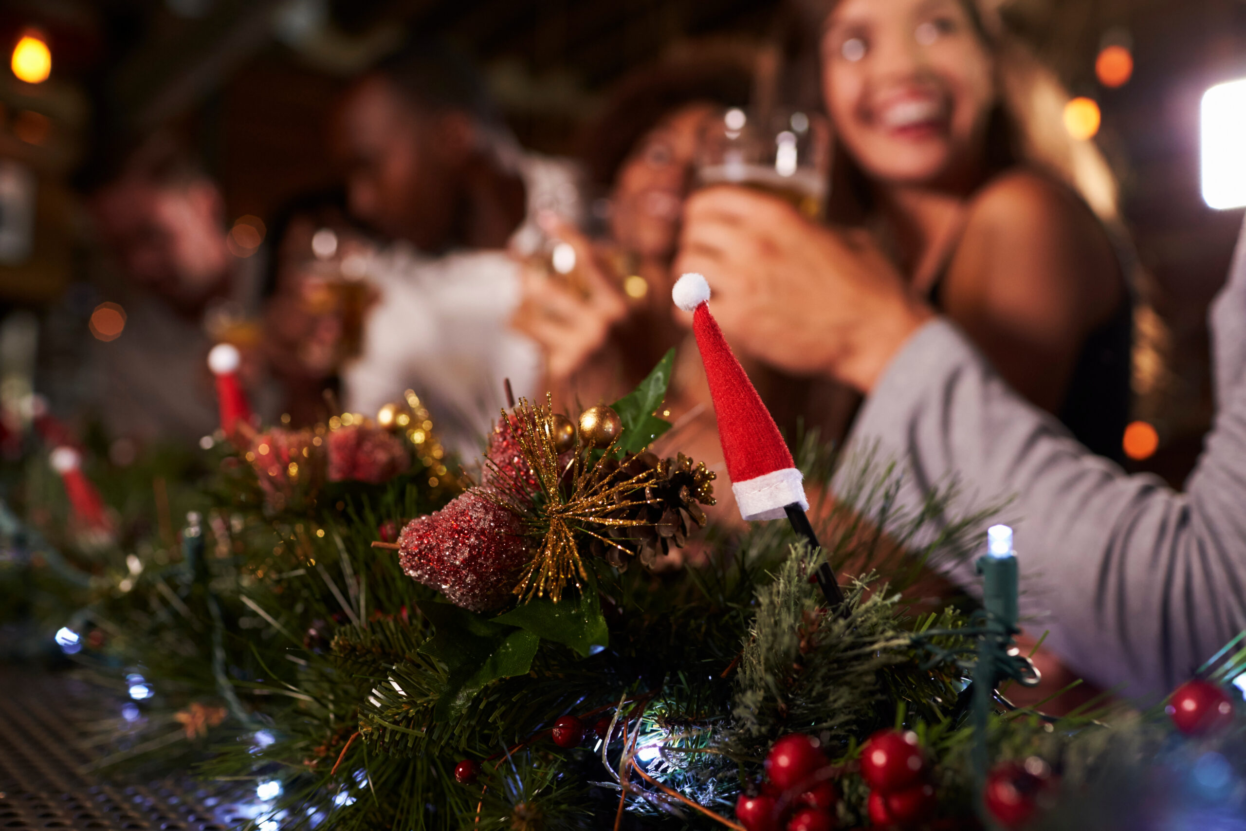 Weihnachtliche Tischdekoration und Menschen im Hintergrund an einem TIsch