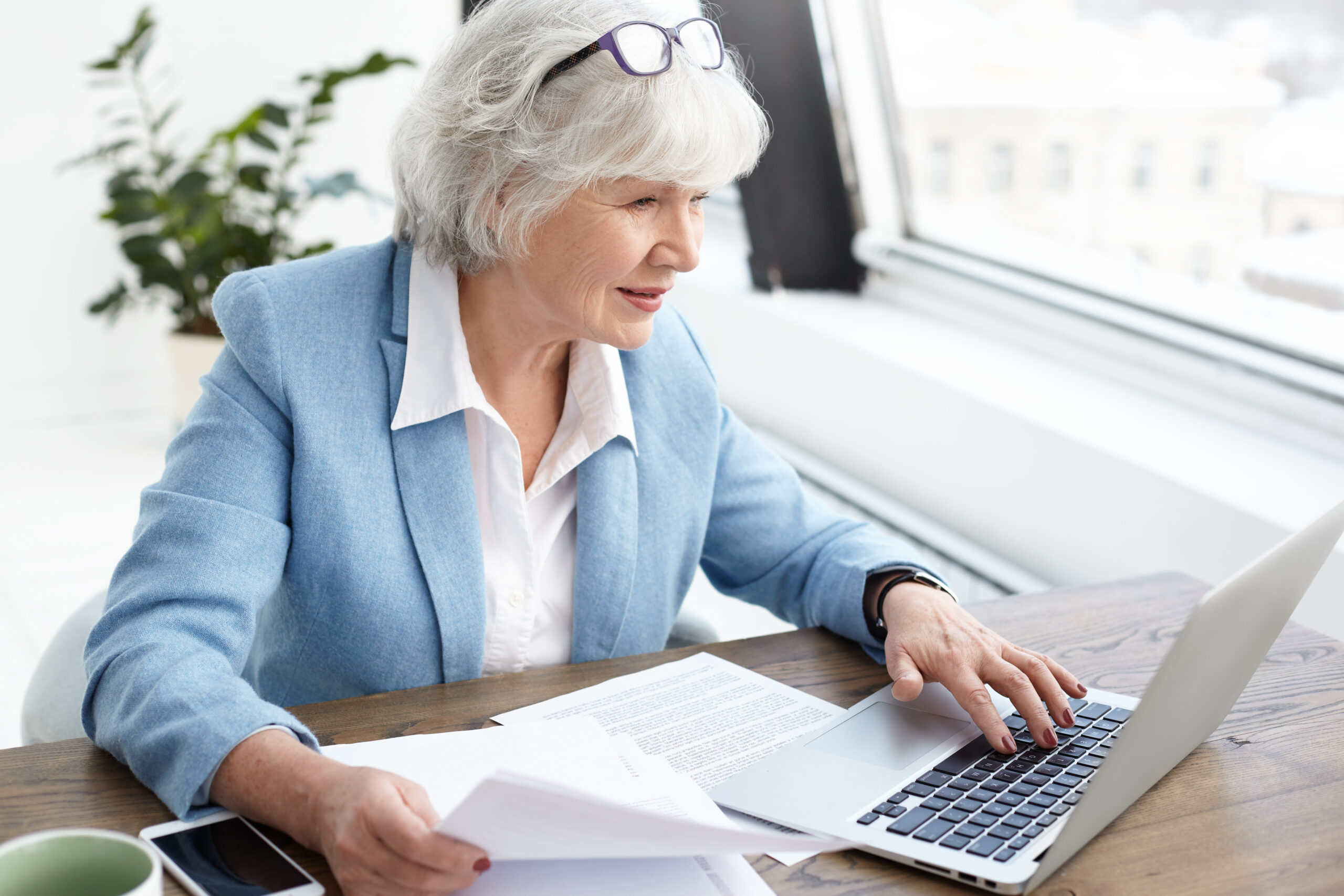 ältere Dame sitzt vor dem Laptop