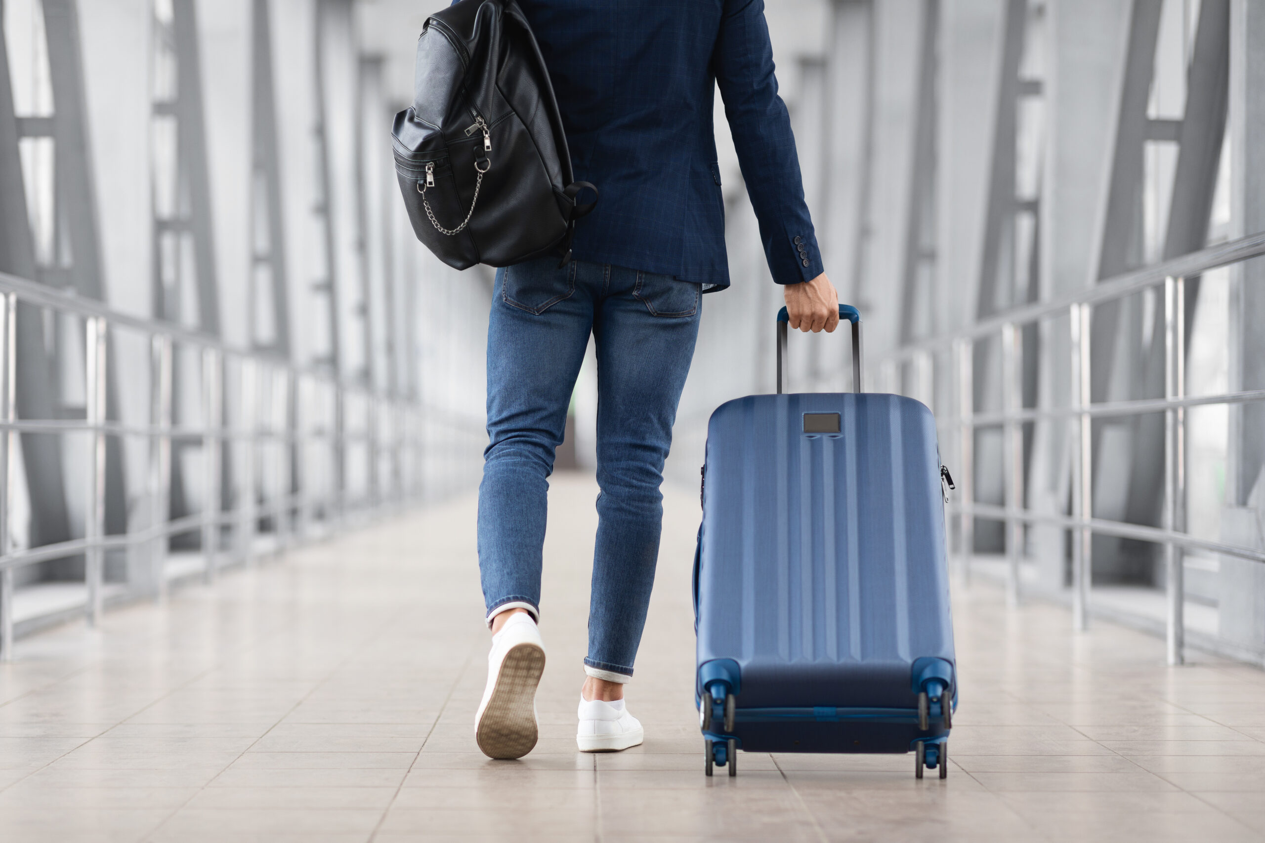 Mann mit Rollkoffer am Flughafen